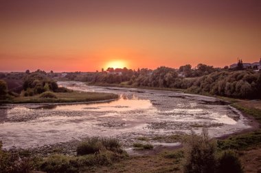 Summer evening on  bank of  river during the sunset_