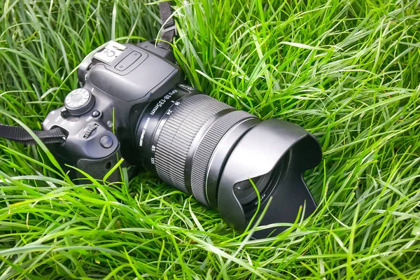 现代数码相机在草地上 旅行期间拍照时暂停 — 图库照片