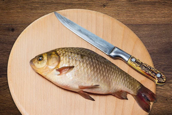 Fish, ready for cooking, and knife on the kitchen board_ — 스톡 사진