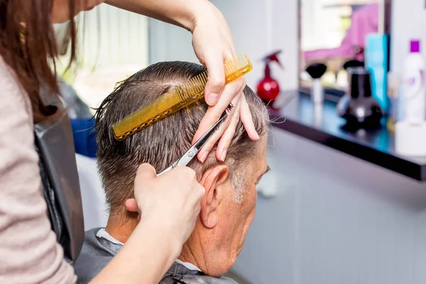 Mestre no salão de cabeleireiro faz penteado elegante para um campo — Fotografia de Stock