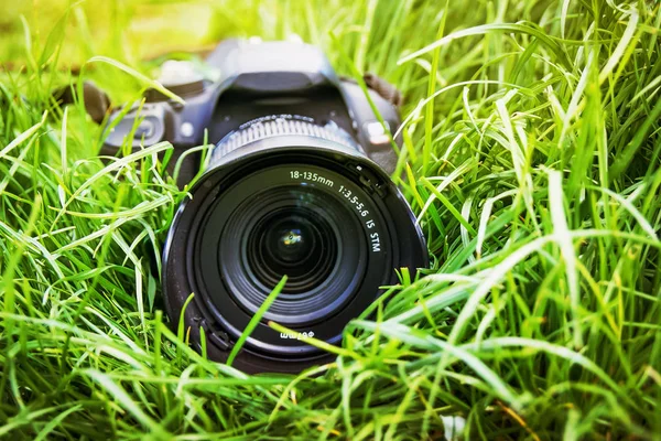 专业摄影器材广告 照相机位于草 — 图库照片