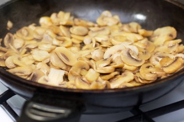 Preparation of champignon in a frying pan in the kitchen_