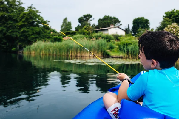 Niño de 12 años pescando en canoa en el lago Monate —  Fotos de Stock