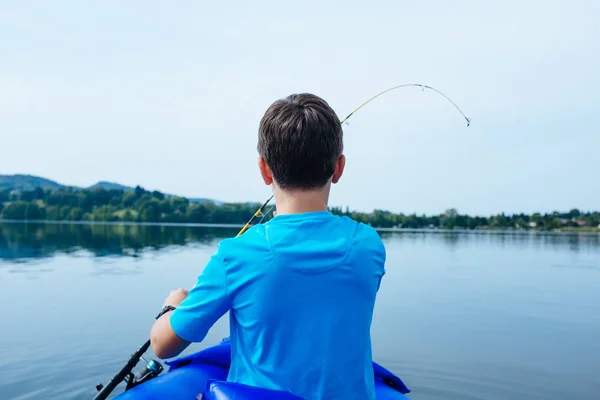 Niño de 12 años pescando en canoa en el lago Monate —  Fotos de Stock