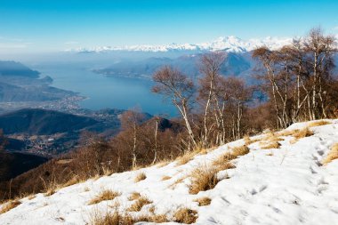 Alp öncesi dağlardan Maggiore Gölü manzarası, kayın ormanları ve çayırlar arasında, Monte Lema kış mevsimi