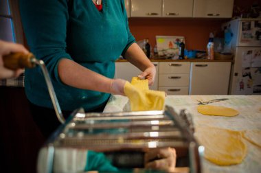 Evde mutfak masasının üzerinde el yapımı el yapımı erişteli taze yumurtalı makarna hazırlıyorum.
