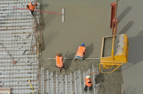 Bygg byggare tillämpa och utjämning cement i bygga s — Stockfoto