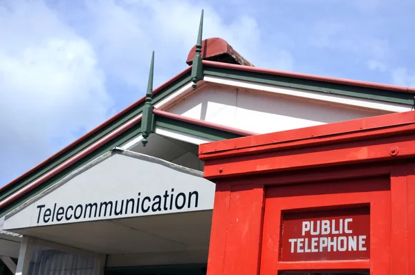 Röd telefonkiosk utanför telekommunikation centrum — Stockfoto