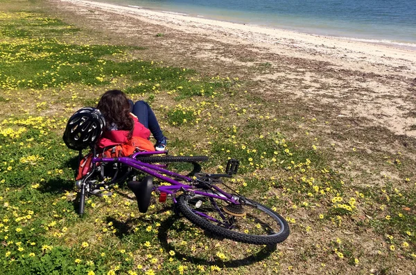 Woman relax on a beach during bicycle journey — Stock Photo, Image