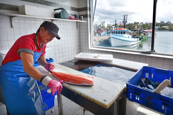 Pescador limpia un pescado en Sydney Fish Market Sydney New South W — Foto de Stock