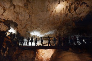 Unrecognisable people visiting inside the Jenolan Caves at Blue Mountains of New South Wales, Australia. clipart