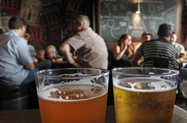 Deux verres de bière sur une table de pub — Photo