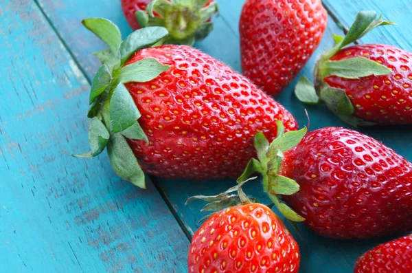 Nahaufnahme von frischen roten Erdbeeren auf einem Holztisch — Stockfoto