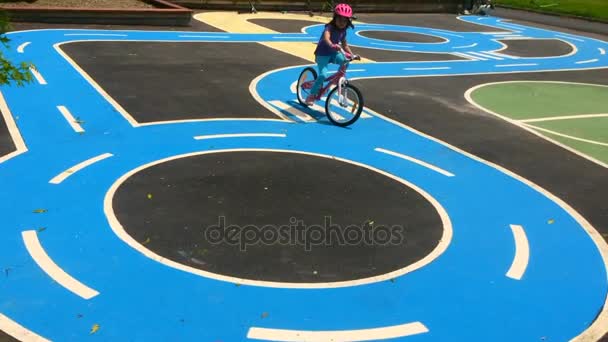 从一辆自行车在公共游乐场的自行车赛道，年轻女孩秋天 — 图库视频影像