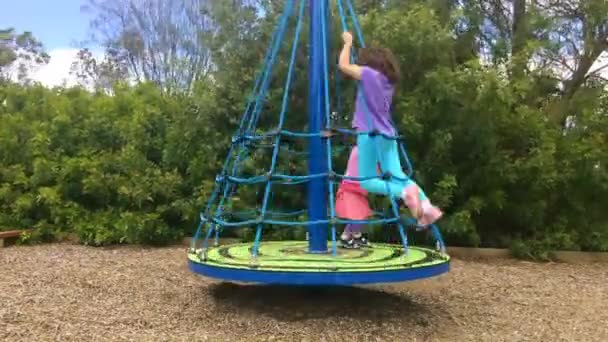 Tijd lapse jonge meisjes spelen op een carrousel — Stockvideo