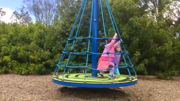 Les jeunes filles jouent sur un carrousel — Video