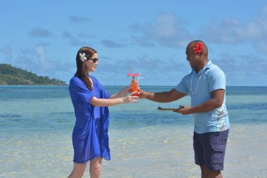 Fiji adam bir turist kadın olarak tropikal kokteyl içki hizmet