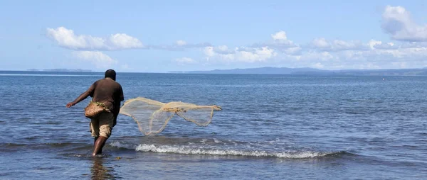 Pescador indígena fiyiano lanzando red de pesca en Fiji — Foto de Stock