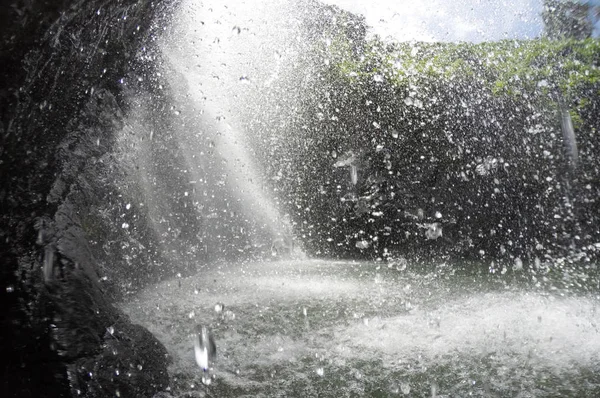 Waterdruppels vallen achter een waterval — Stockfoto