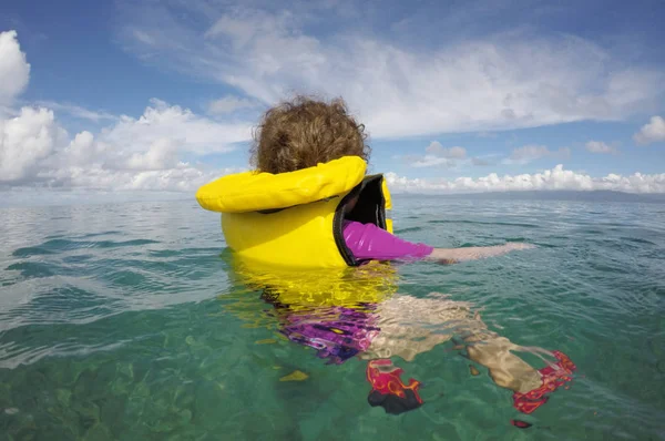 Niño flotando con un chaleco salvavidas solo en el océano —  Fotos de Stock