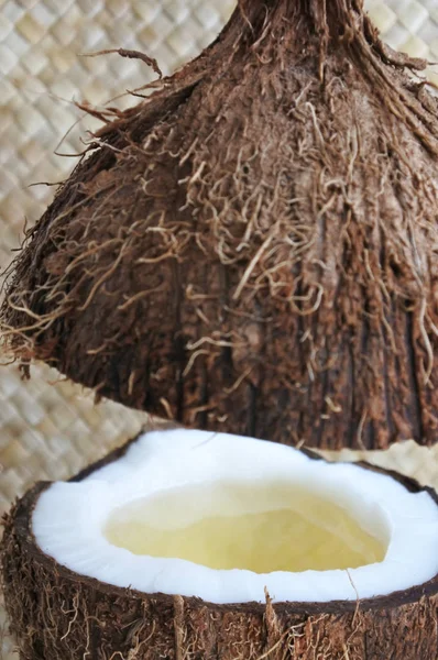 Una fruta de palma de coco abierta con aceite de coco en ella — Foto de Stock