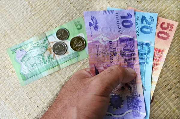Turista segurar uma moeda fijiana — Fotografia de Stock