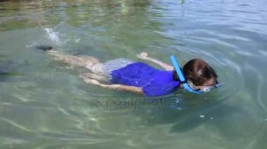 Genç kadın bir tropikal tatil beldesine şnorkel
