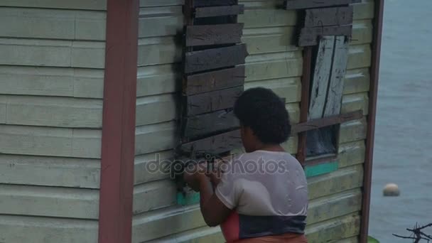 Mujer fiyiana que embarca en su casa durante un ciclón tropical — Vídeo de stock