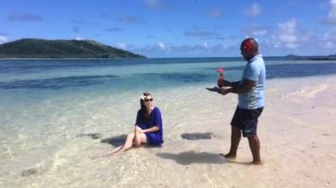 Fiji adam bir turist kadına Fiji bir adada bir tatil tropikal kokteyl içki hizmet. Seyahat tatil tatil kavramı. Gerçek insanlar alanı Kopyala