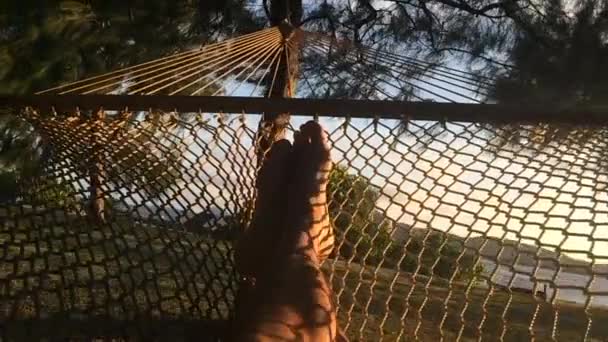 Füße eines Mannes, der sich in einer Hängematte entspannt — Stockvideo