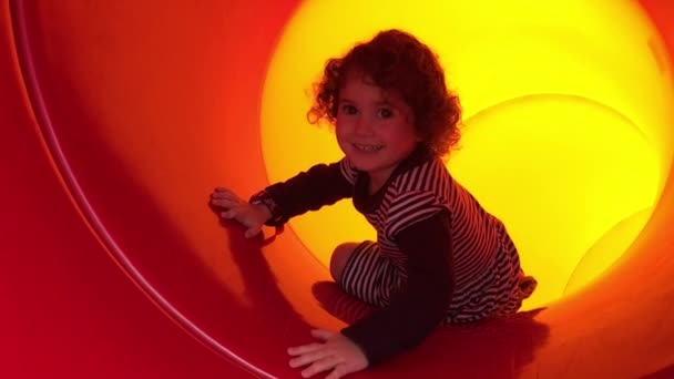 Meisje glijdend van een dia in de speeltuin — Stockvideo