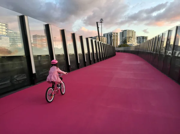 Junges mädchen radelt auf leuchtend rosa radweg in auckland new — Stockfoto