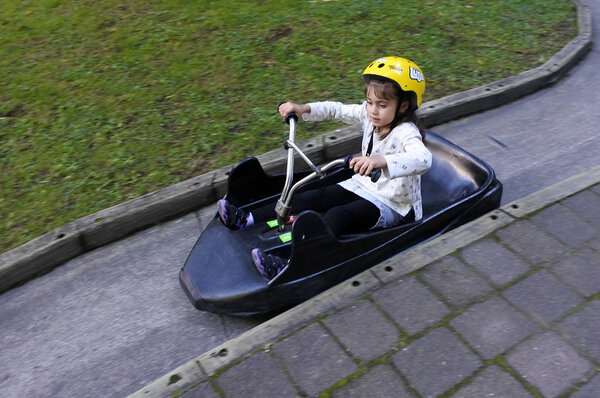 Молодая девушка едет на Skyline Rotorua Luge
