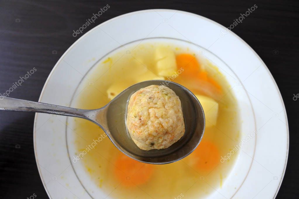 Flat lay view of one Matzah balls, Ashkenazi Jewish soup dumpling made from a mixture of matzah meal, eggs, water and chicken fat served on Passover Jewish Holiday.Food background and texture