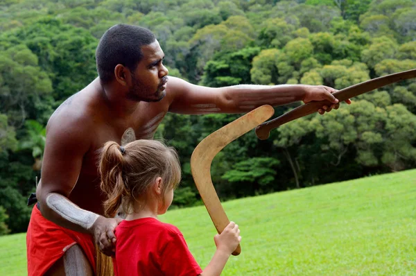 Aboriginal Australians man teaches a young girl how to throw a b — Stock Photo, Image