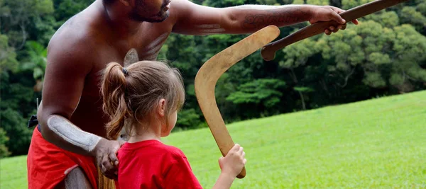 Australians aboriginals man teaches a young girl how to throw a — Stock Photo, Image