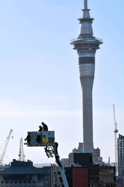 Firefighters on a Crane Platform against Auckland Sky Tower — Stock Photo, Image