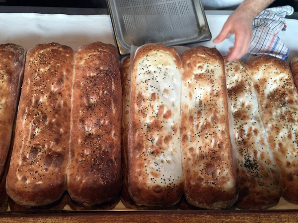 Bäcker backt warme Brote in einer Bäckerei — Stockfoto