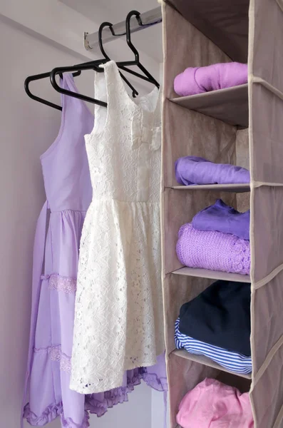 Young girls clothes hanging in open wardrobe — Stock Photo, Image