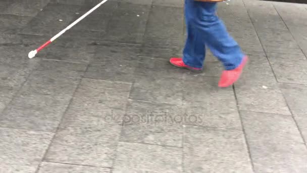 Blind person walks with a long white cane stick — Stock Video