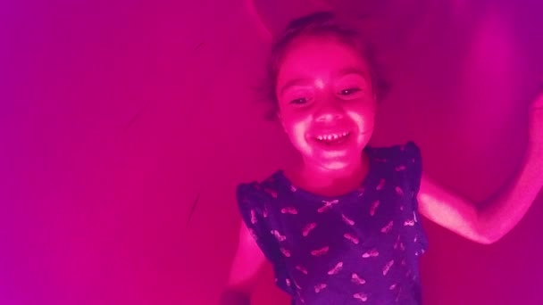 Menina deslizando para baixo um slide no playground — Vídeo de Stock