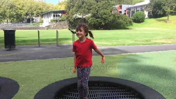 Szczęśliwa dziewczyna skacze na zewnątrz trampoliny — Wideo stockowe