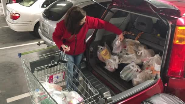 Vrouw boodschappen in haar auto laden na het winkelen — Stockvideo