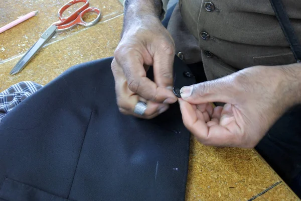 Kleermaker naaien een knop — Stockfoto