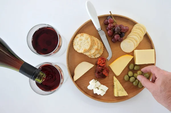 Kırmızı Şarap Iki Kadehlerin Dökülür Bir Zeytin Peynir Tabağı Seçme — Stok fotoğraf