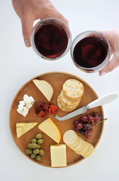 Mann und Frau jubeln bei Wein über Käseplatte — Stockfoto