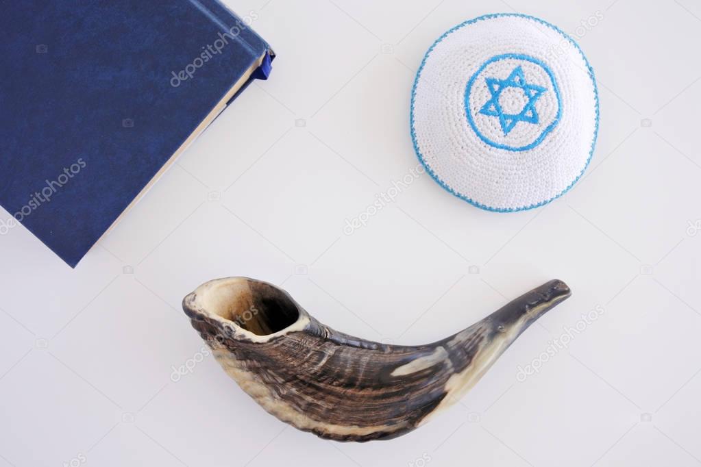 Flat lay view of Shofar, Torah book and Kippa background