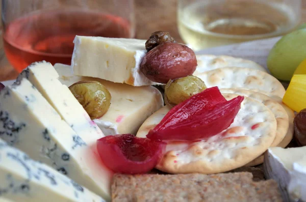 Piatto di formaggio servito con rosa e vino bianco — Foto Stock