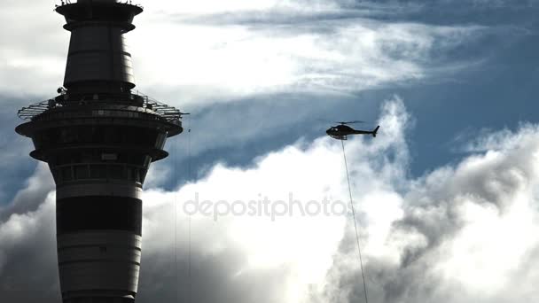 直升机运送货物在天空塔奥克兰旁边 — 图库视频影像