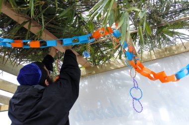 Yahudi Ortodoks adam bir Sukkah dekorasyon